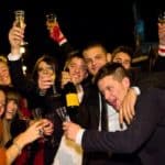 Amici festeggiano compleanno dei 18 anni con bottiglia di champagne vicino hummer limousine