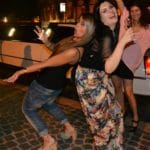 Ragazze con bicchieri di prosecco in mano si divertono al Colosseo vicino limousine